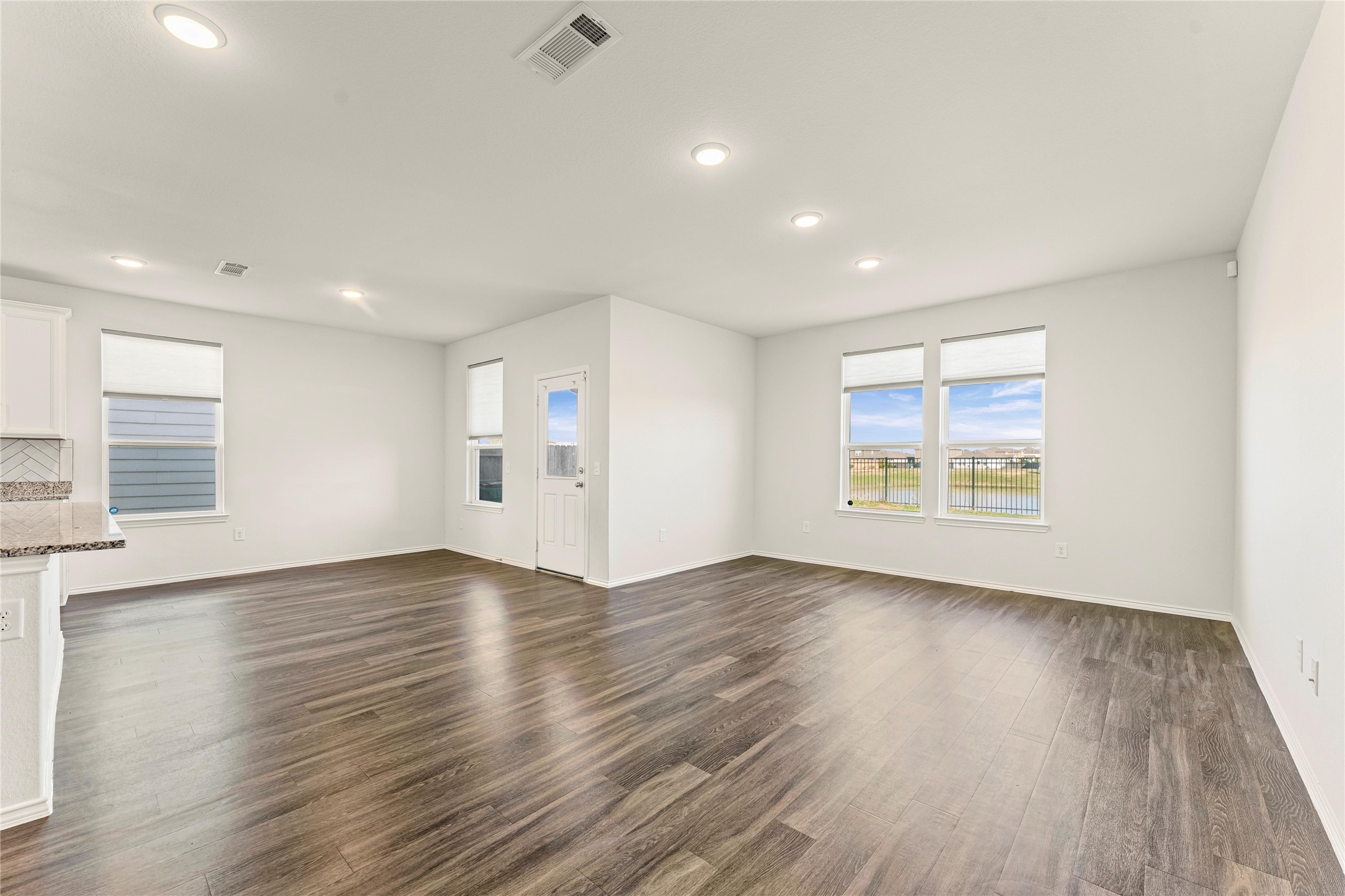 5826 Savanna Pasture Road Katy, TX 77493 - Photo 22 of 45 an empty room with wooden floor and windows