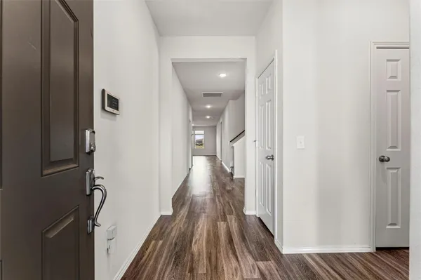 a view of a hallway with wooden floor and staircase