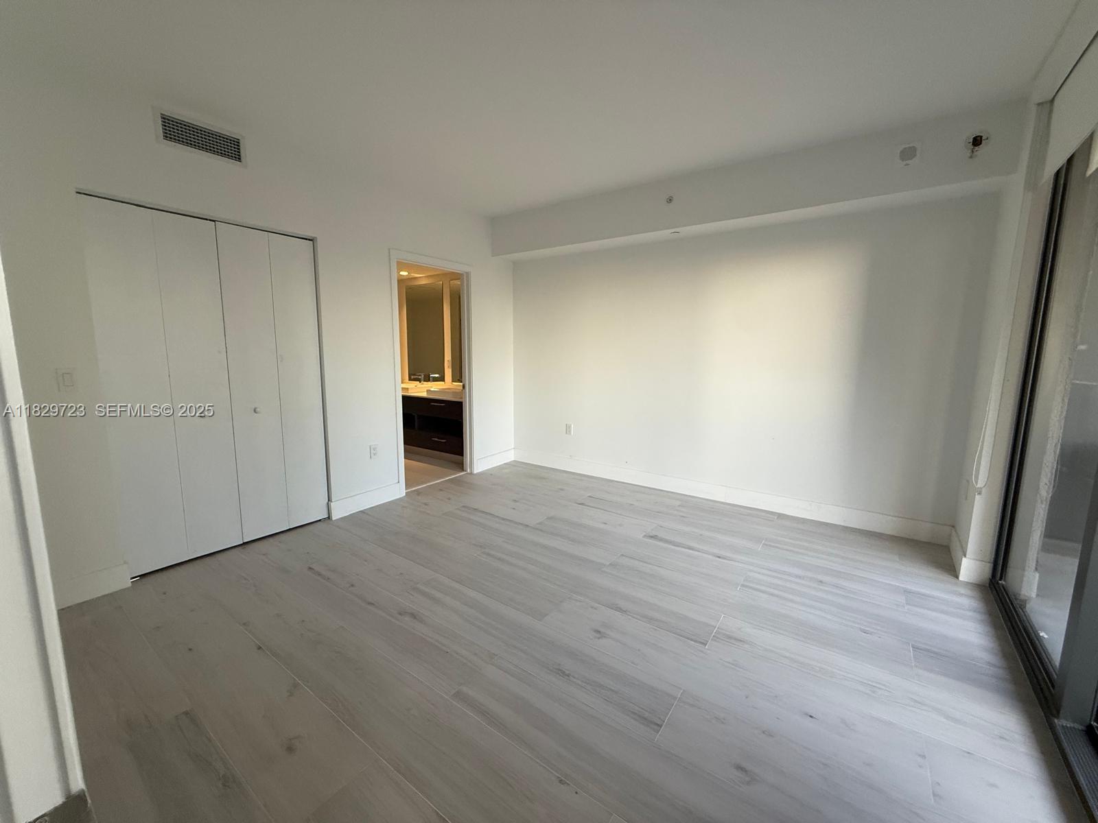 45 Southwest 9th Street, Unit 1706 Miami, FL 33130 - Photo 6 of 29 a view of an empty room with wooden floor and a window