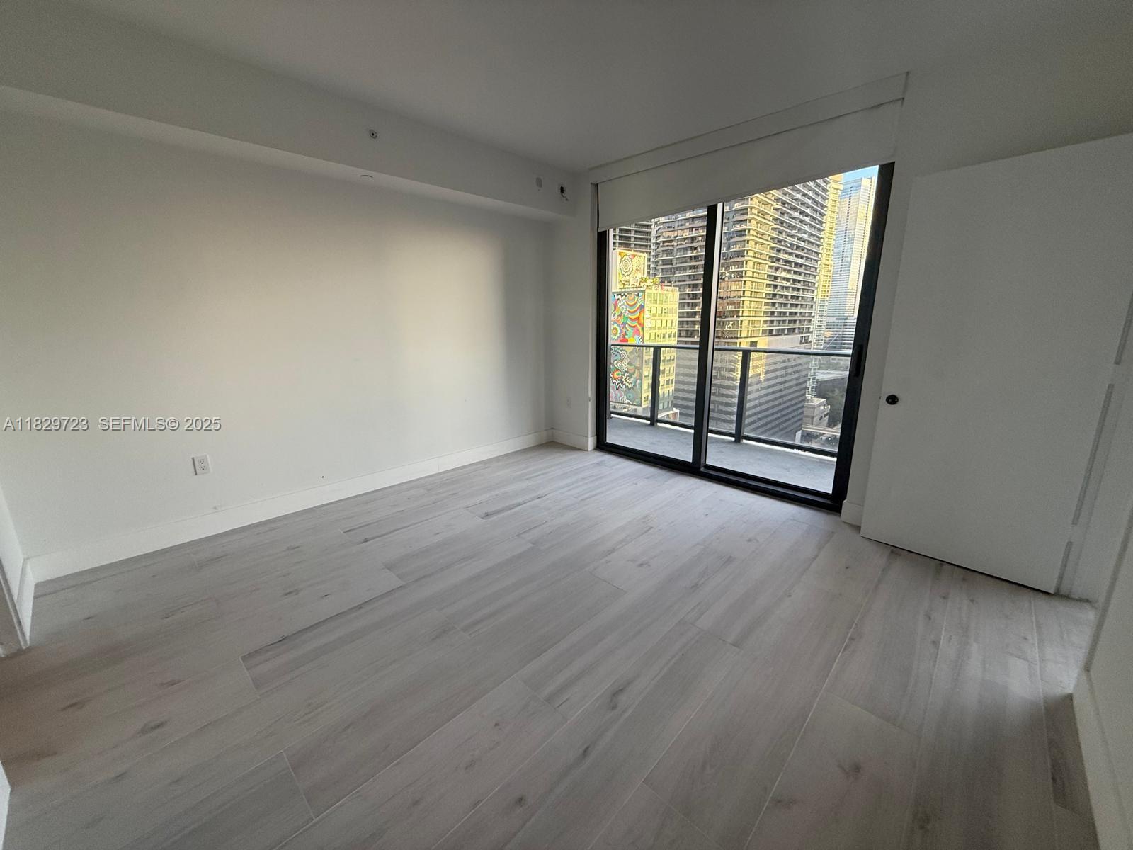 45 Southwest 9th Street, Unit 1706 Miami, FL 33130 - Photo 7 of 29 wooden floor in an empty room with a window