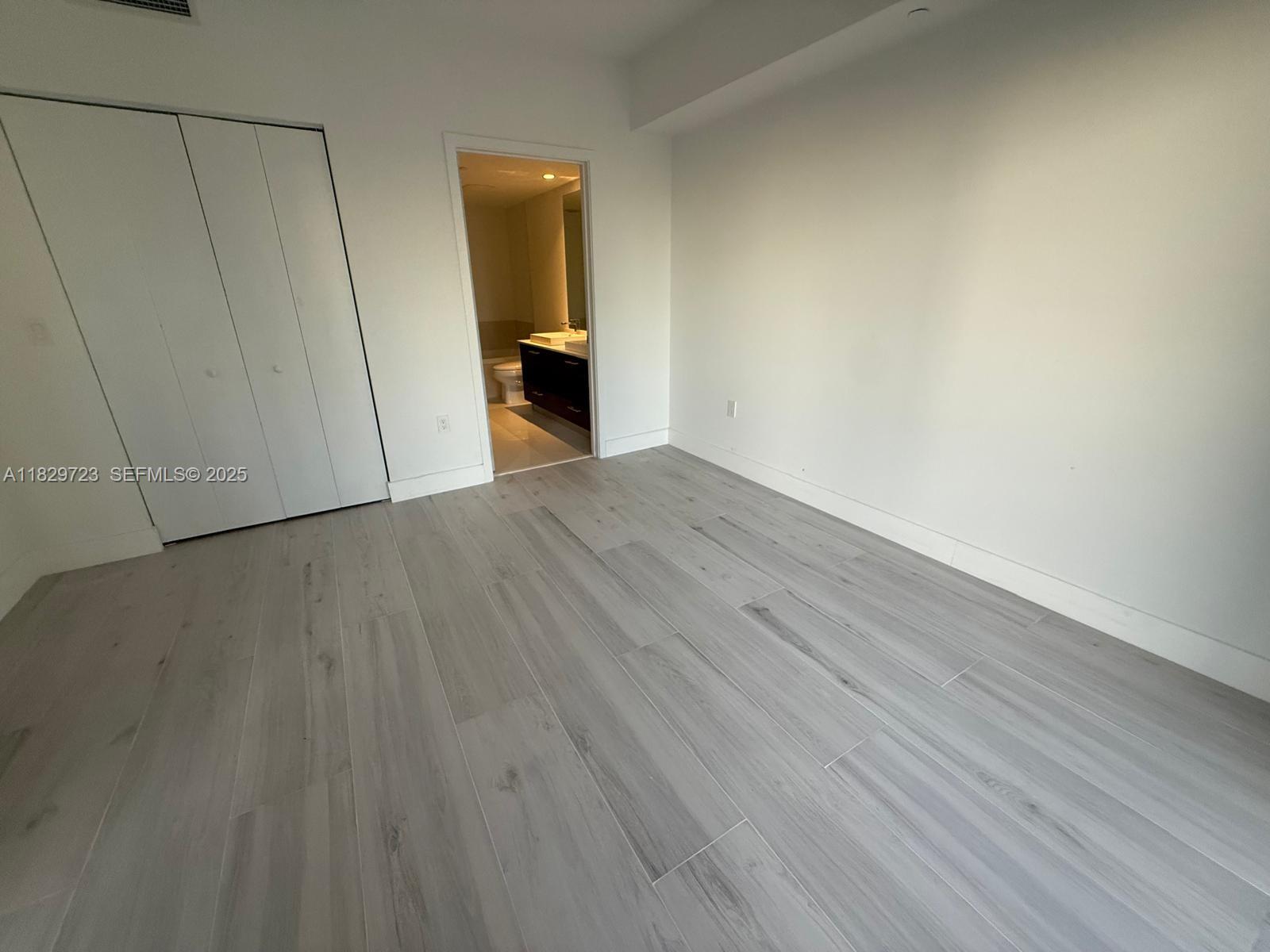 45 Southwest 9th Street, Unit 1706 Miami, FL 33130 - Photo 8 of 29 a view of an empty room with wooden floor and a window
