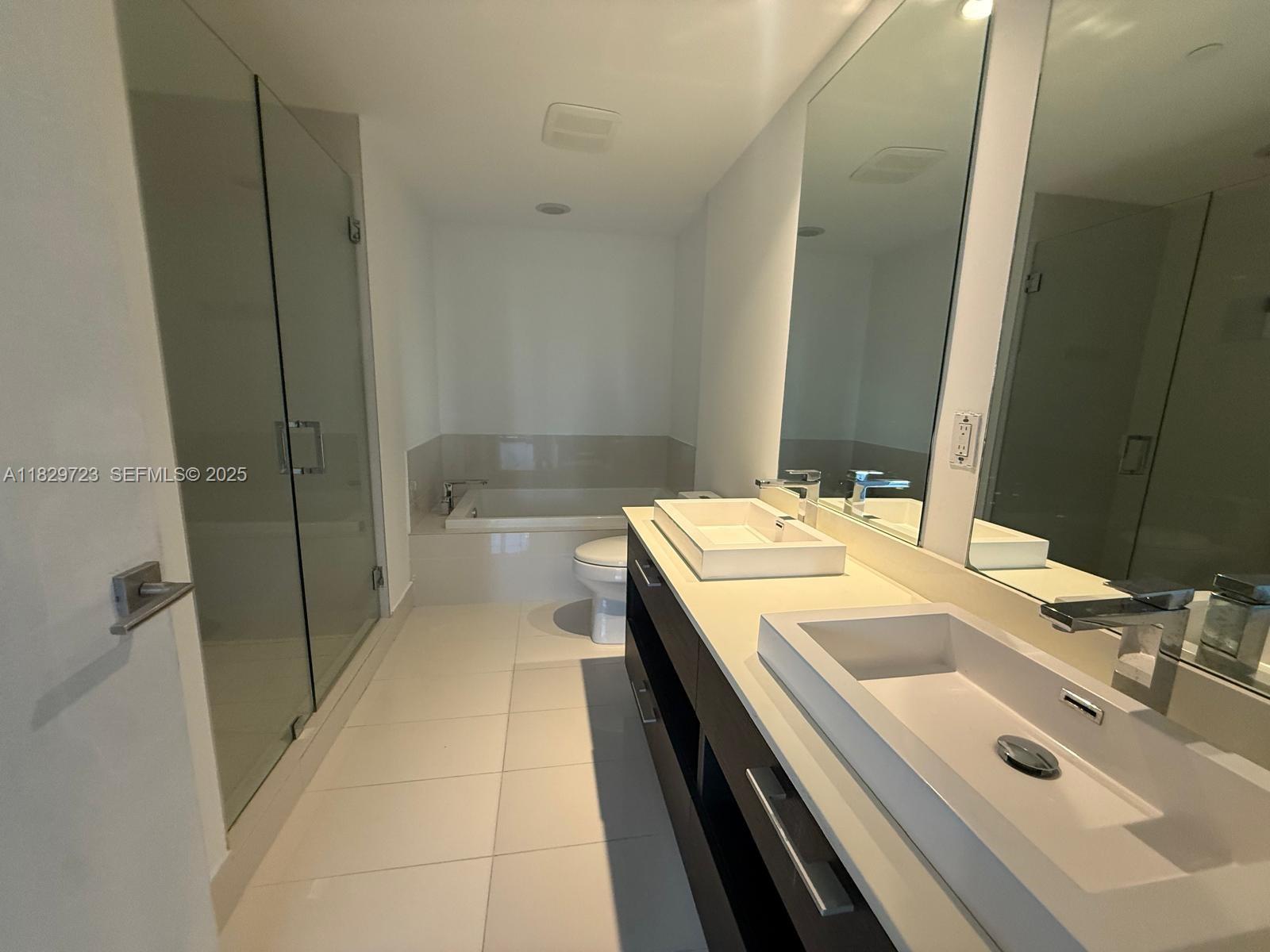 45 Southwest 9th Street, Unit 1706 Miami, FL 33130 - Photo 9 of 29 a bathroom with a sink a toilet and shower