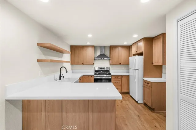 a kitchen with a sink a refrigerator a counter top space and cabinets