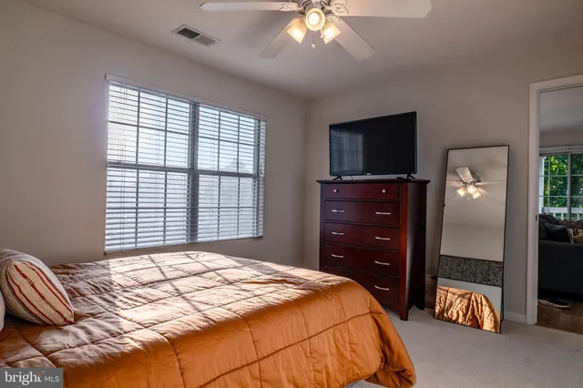 a bedroom with a bed and a flat tv screen on dresser
