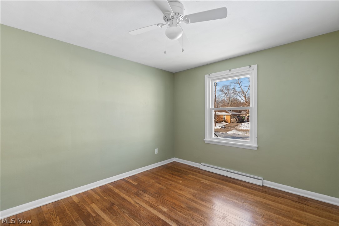 136 South Metzger Avenue Rittman, OH 44270 - Photo 29 of 33 Unfurnished room featuring a baseboard heating unit, hardwood / wood-style flooring, and ceiling fan