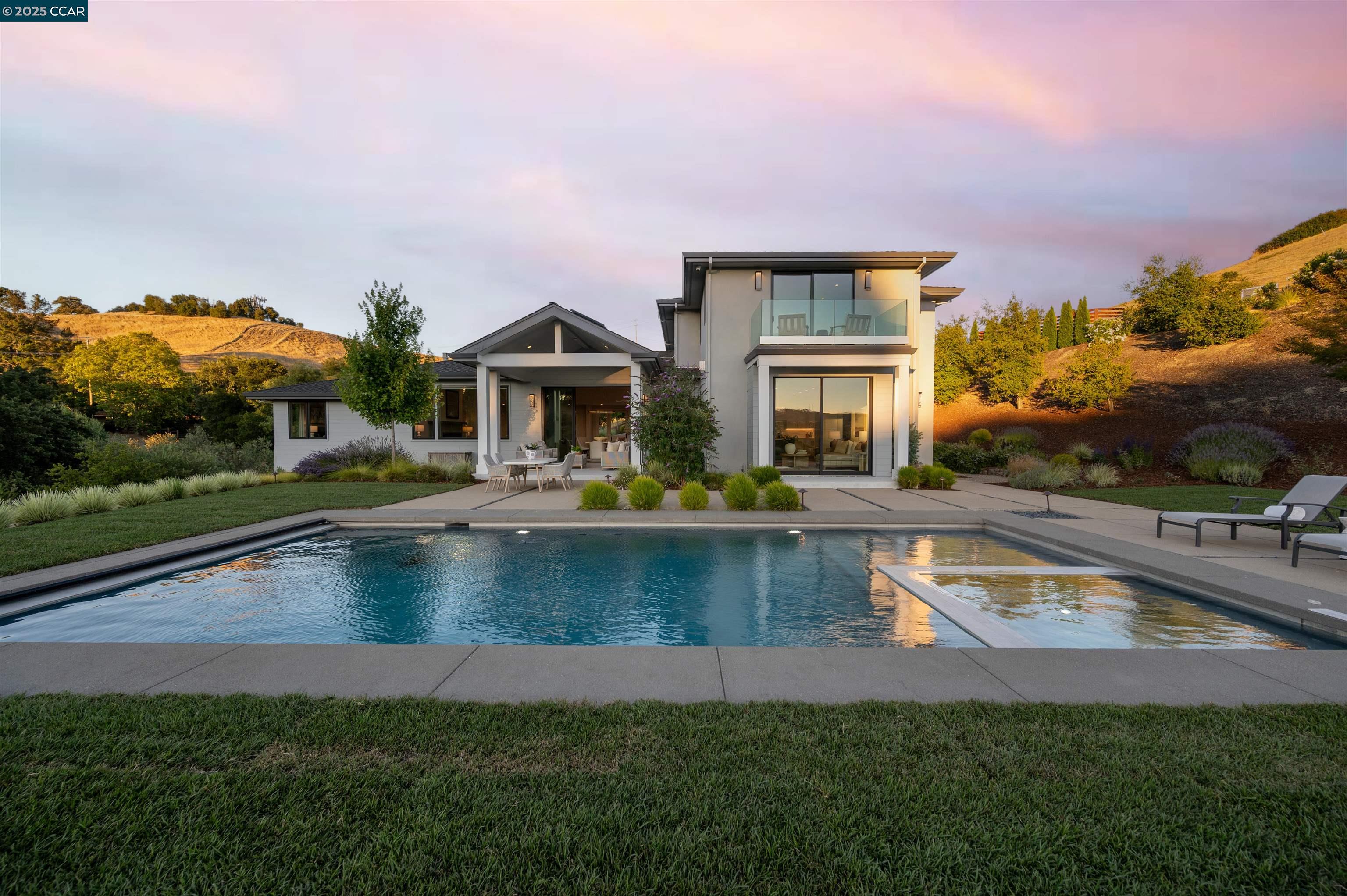 a view of a house with pool and a yard