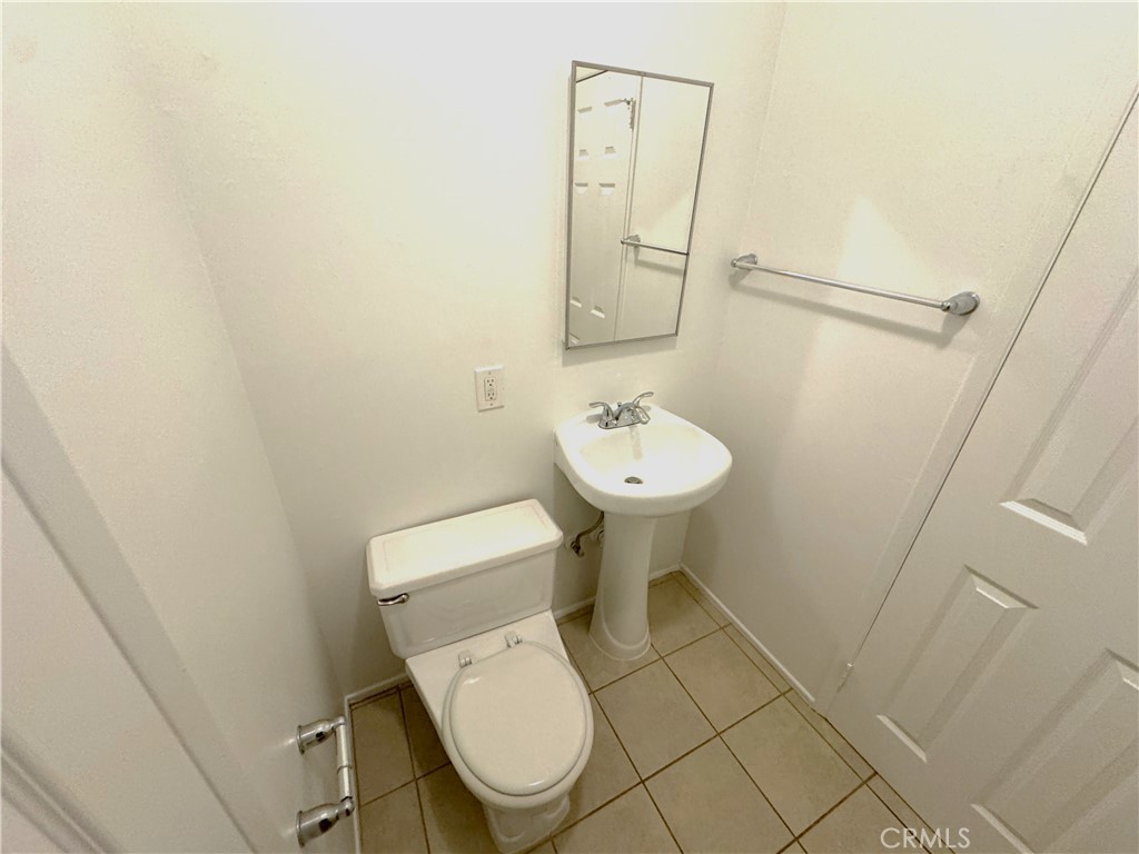 44450 Lowtree Avenue Lancaster, CA 93534 - Photo 11 of 24 a white toilet sitting next to a small sink