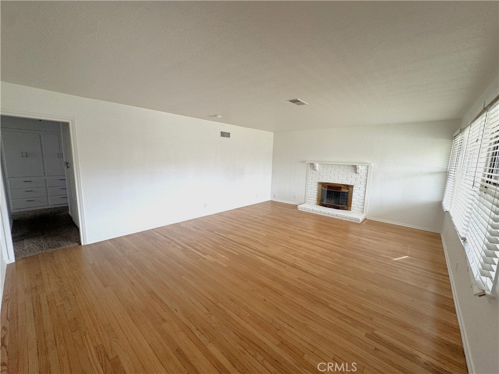 44450 Lowtree Avenue Lancaster, CA 93534 - Photo 4 of 24 a view of empty room with wooden floor and window