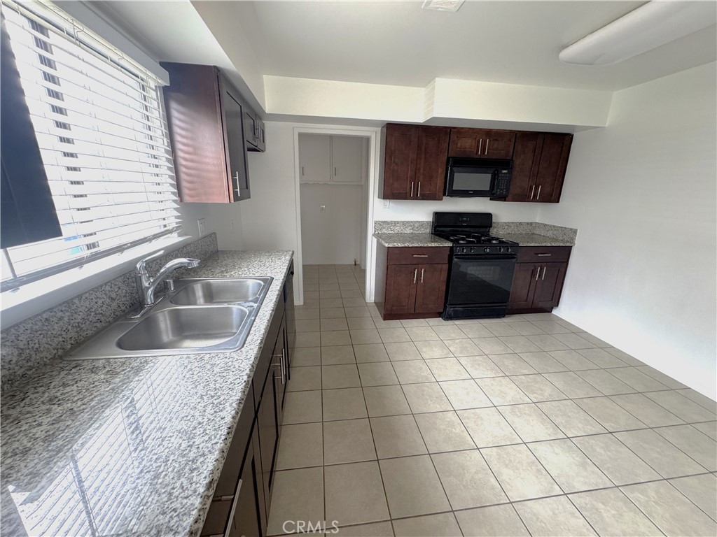 44450 Lowtree Avenue Lancaster, CA 93534 - Photo 8 of 24 a kitchen with stainless steel appliances granite countertop a sink stove and microwave
