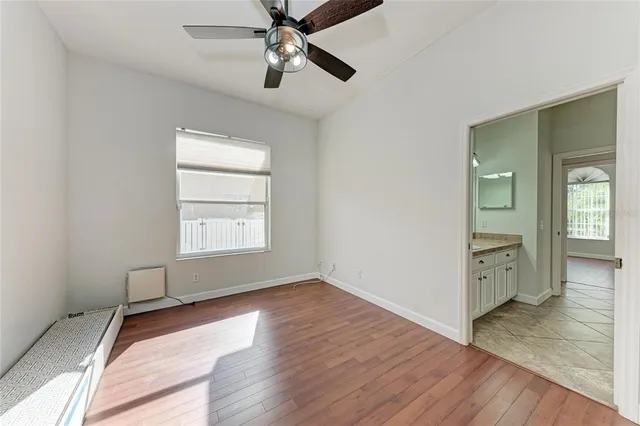 a view of a room with a ceiling fan and window