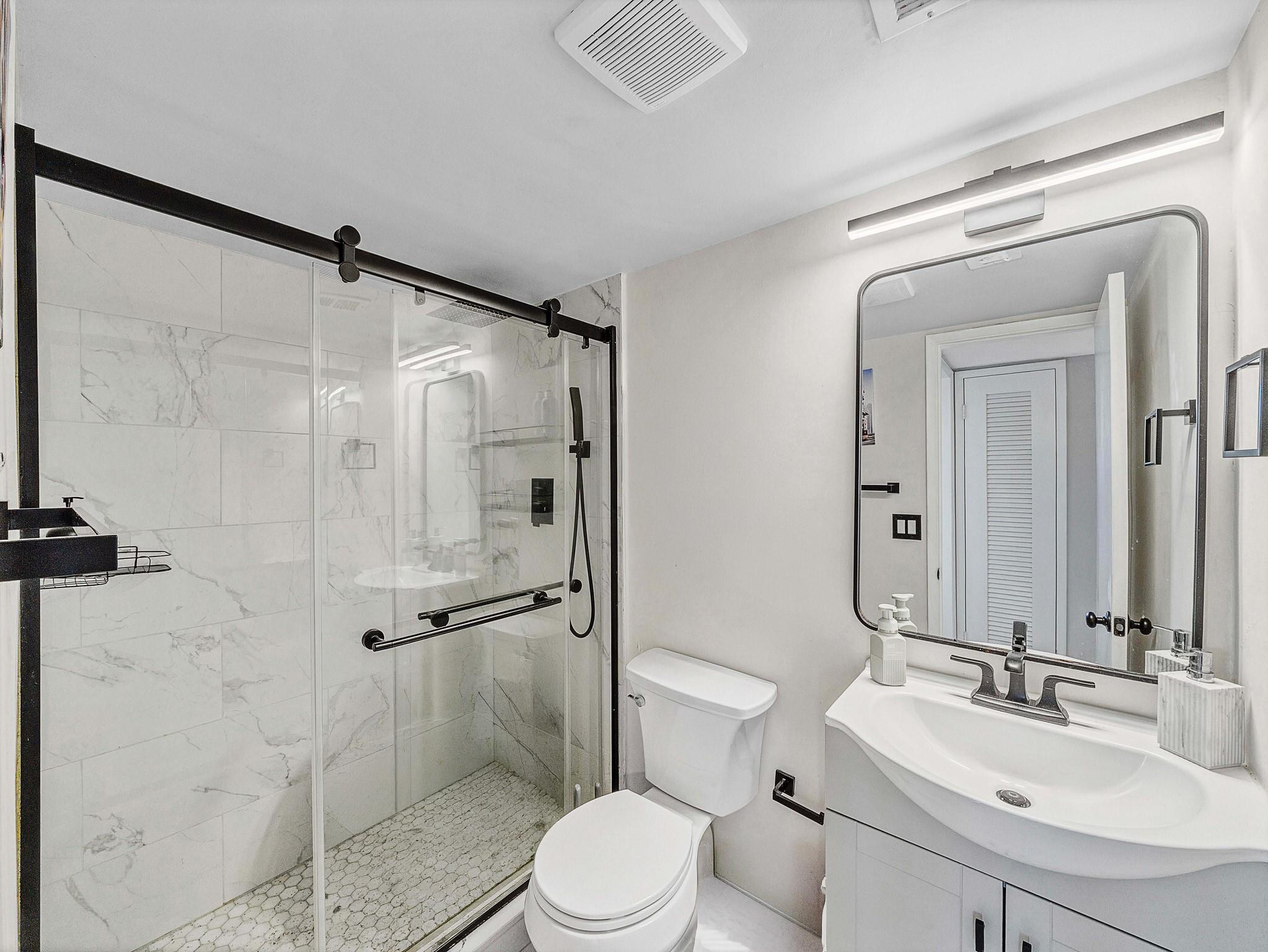 4500 North Federal Highway, Unit 303 Lighthouse Point, FL 33064 - Photo 12 of 40 a bathroom with a sink toilet and shower