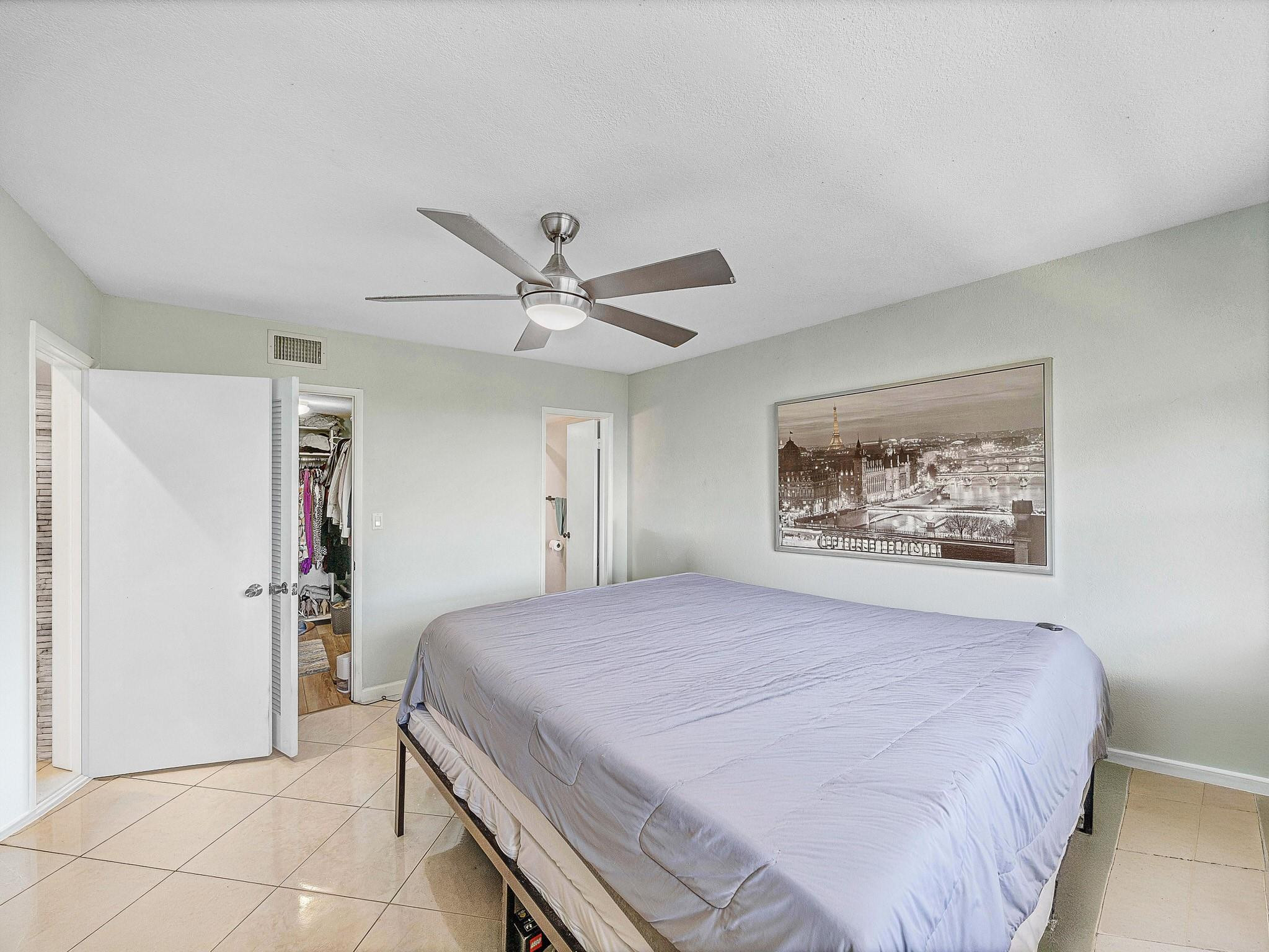 4500 North Federal Highway, Unit 303 Lighthouse Point, FL 33064 - Photo 25 of 40 a bedroom with a large bed and a chandelier