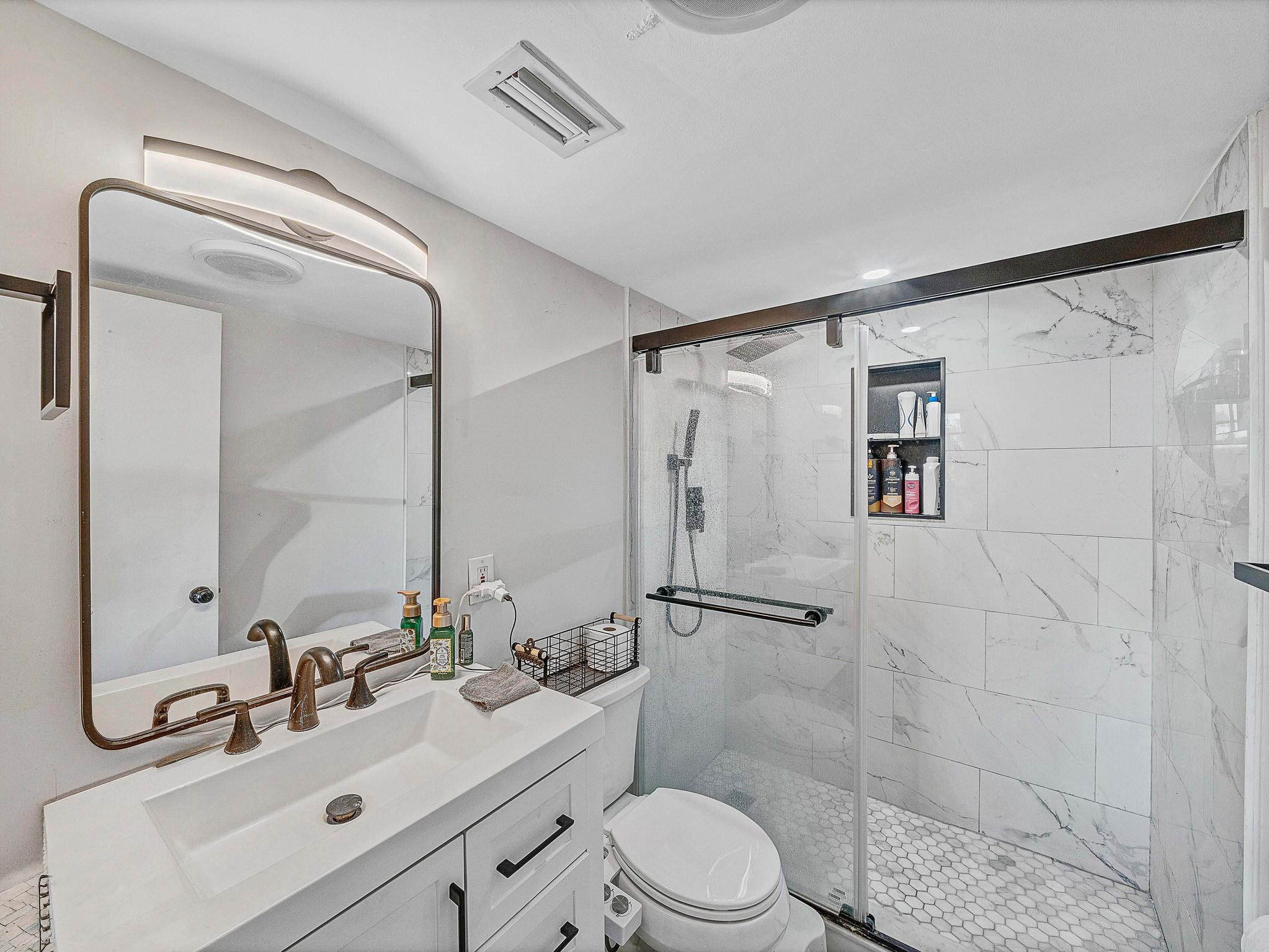 4500 North Federal Highway, Unit 303 Lighthouse Point, FL 33064 - Photo 28 of 40 a bathroom with a sink mirror toilet and shower