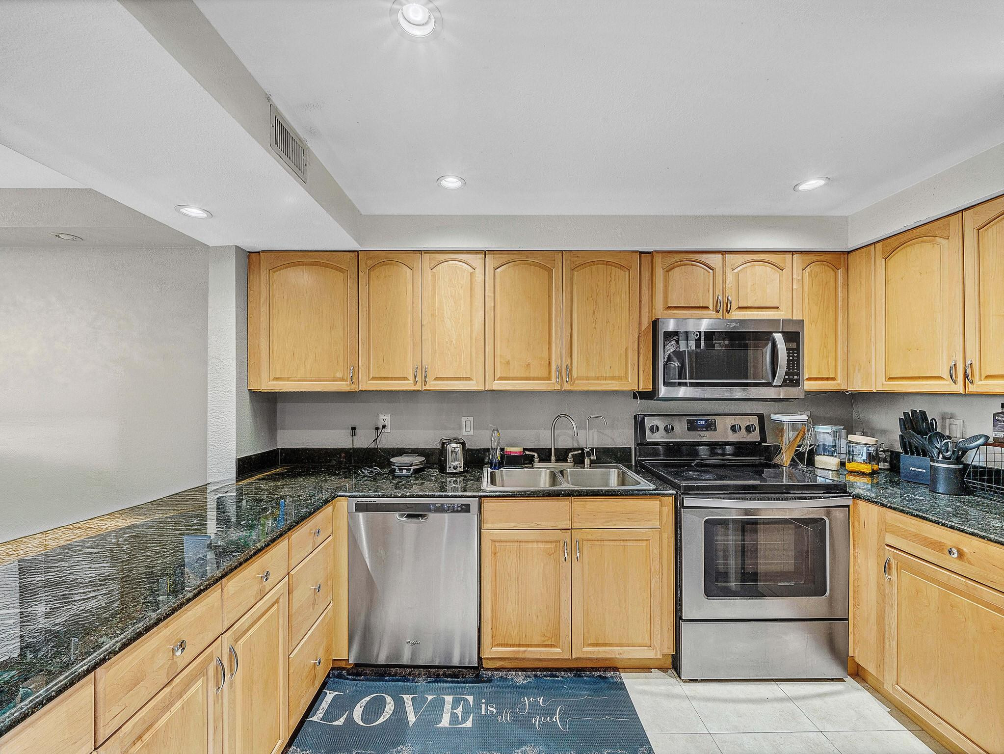 4500 North Federal Highway, Unit 303 Lighthouse Point, FL 33064 - Photo 10 of 40 a kitchen with stainless steel appliances granite countertop a stove a sink and a microwave