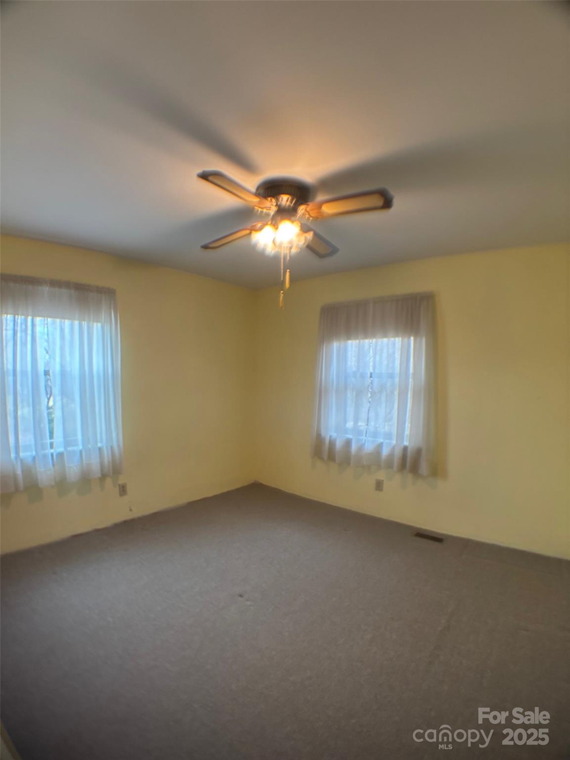 150 Old Georgia Road Statesville, NC 28625 - Photo 13 of 42 an empty room with a chandelier fan and windows