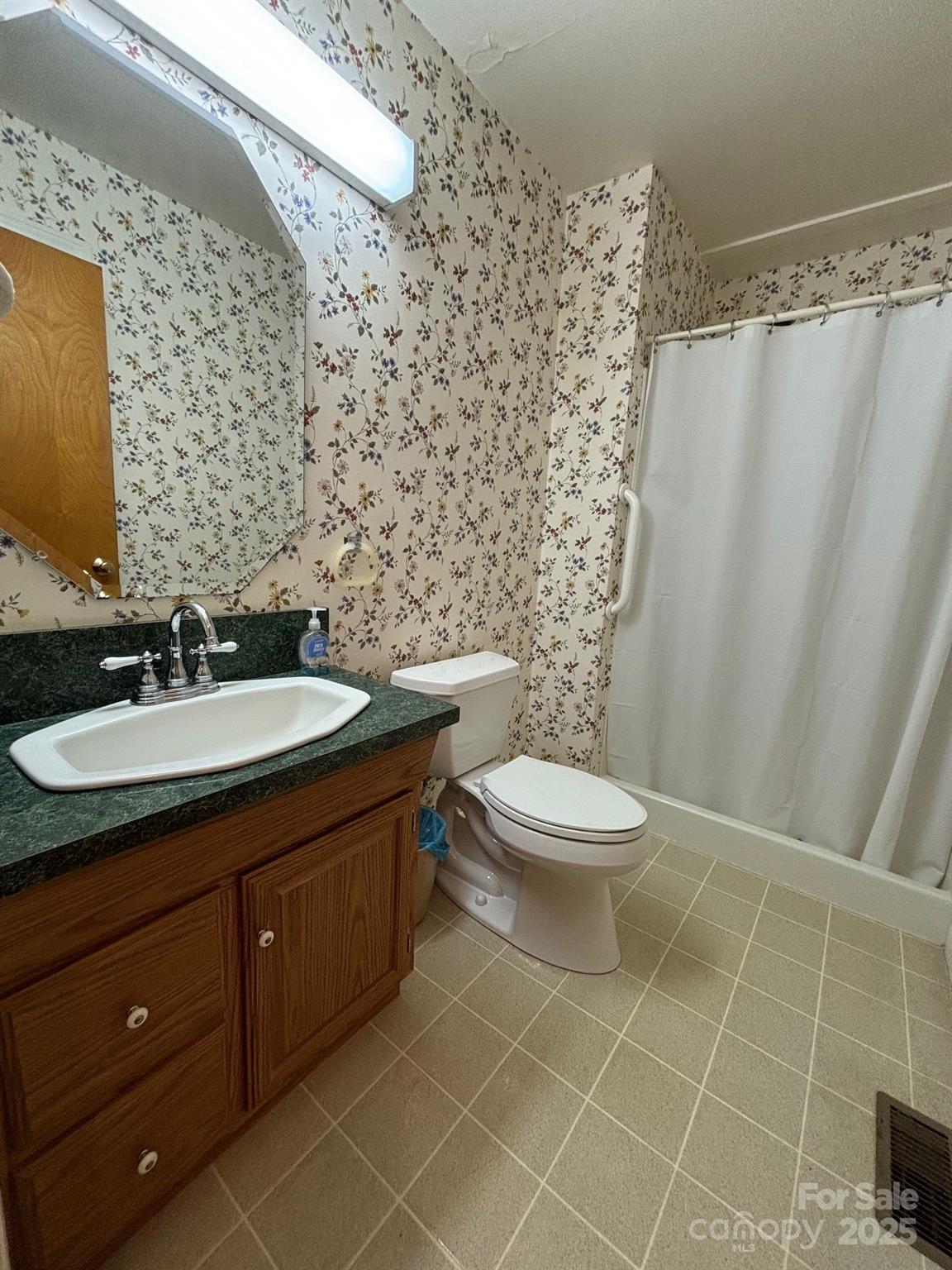 150 Old Georgia Road Statesville, NC 28625 - Photo 22 of 42 a bathroom with a granite countertop toilet a sink and a mirror