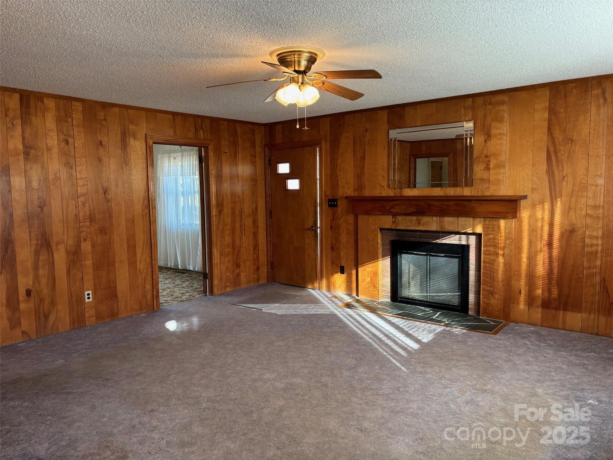 150 Old Georgia Road Statesville, NC 28625 - Photo 5 of 42 a view of an empty room with a fireplace and a ceiling fan