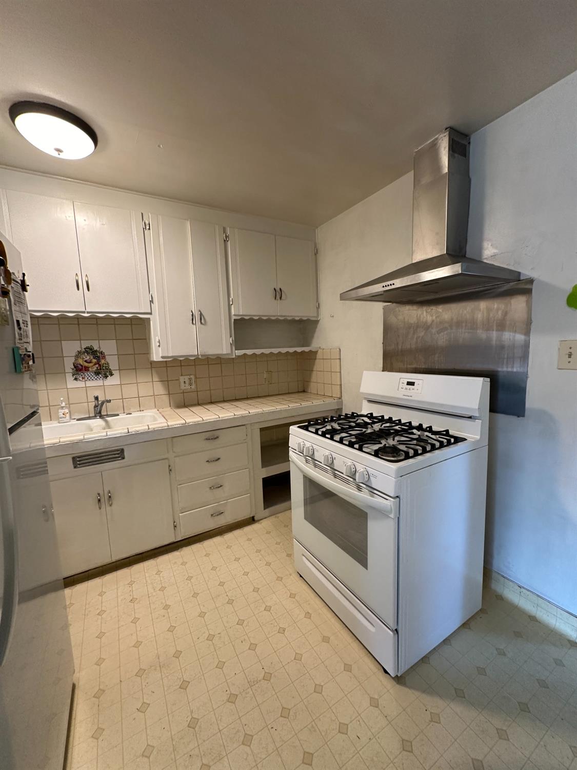 915 West Fountain Way Fresno, CA 93705 - Photo 16 of 20 a kitchen with a stove a sink and a refrigerator