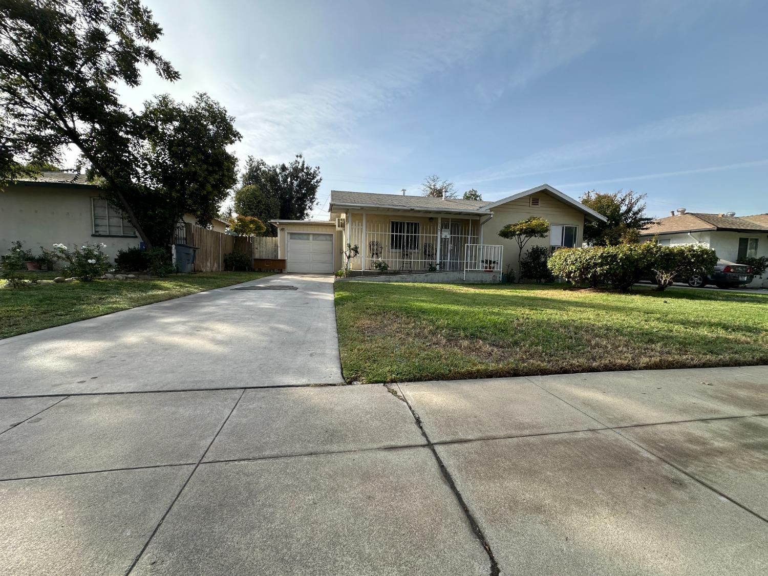 915 West Fountain Way Fresno, CA 93705 - Photo 2 of 20 a front view of a house with a yard and a garage