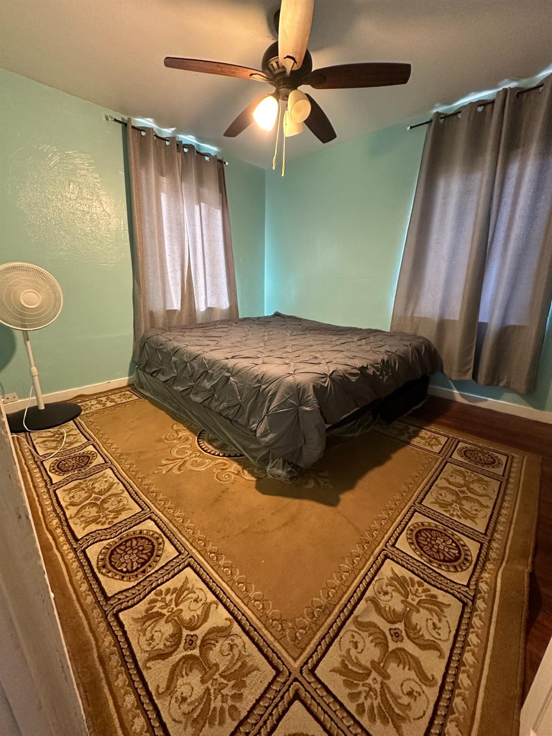 915 West Fountain Way Fresno, CA 93705 - Photo 9 of 20 a bedroom with a bed and a chandelier