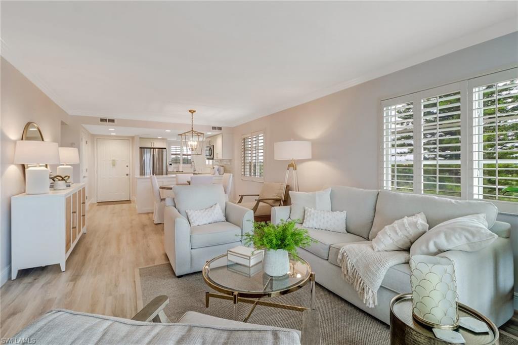 21 High Point Circle East, Unit 601 Naples, FL 34103 - Photo 8 of 22 a living room with furniture and a large window