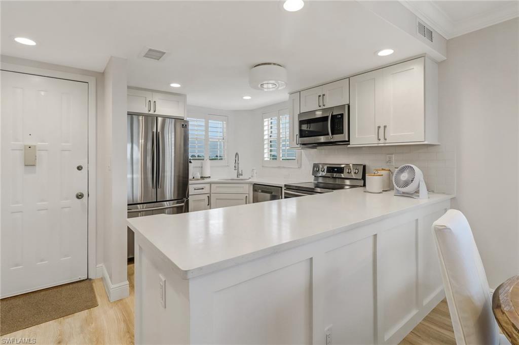 21 High Point Circle East, Unit 601 Naples, FL 34103 - Photo 10 of 22 a kitchen with stainless steel appliances a refrigerator sink and microwave