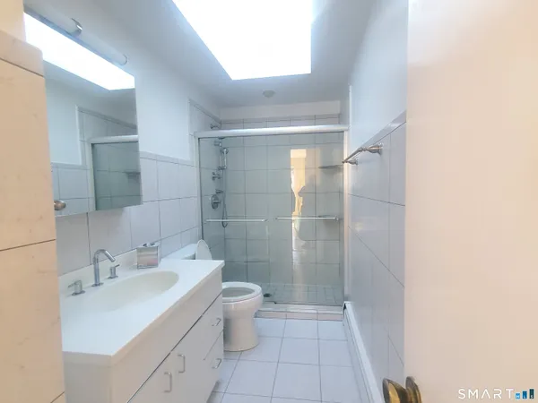 a bathroom with a granite countertop sink a toilet and shower
