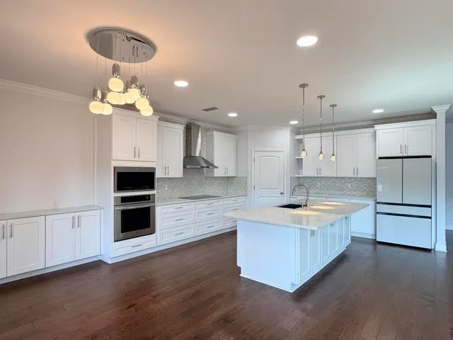 a large kitchen with kitchen island a sink stainless steel appliances and cabinets