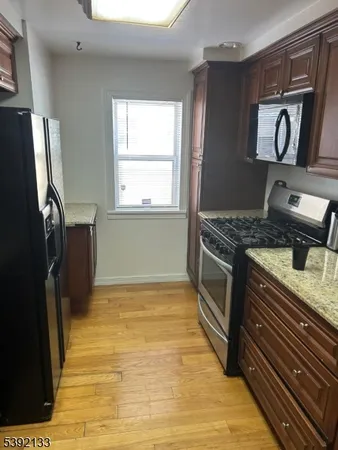 a kitchen with stainless steel appliances granite countertop a refrigerator a stove and a sink