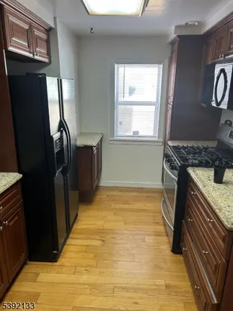 a kitchen with stainless steel appliances granite countertop a refrigerator and a stove top oven