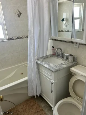 a bathroom with a granite countertop toilet sink and mirror