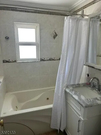 a bathroom with a granite countertop sink and a bathtub