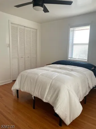 a large bed sitting in a bedroom next to a window and wooden floor