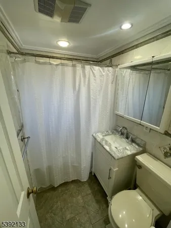 a bathroom with a granite countertop sink toilet and shower