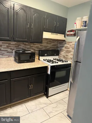 a kitchen with stainless steel appliances granite countertop a stove and a cabinets