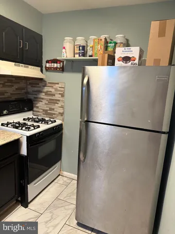 a kitchen with stainless steel appliances granite countertop a refrigerator stove a sink dishwasher and a refrigerator