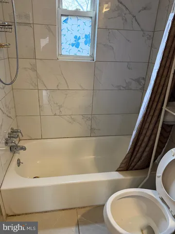 a bathroom with a toilet and bathtub
