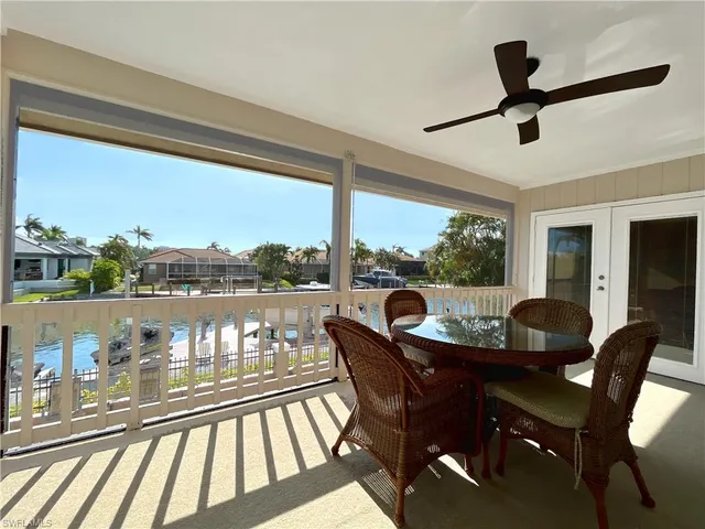 a view of a chairs and table in patio with a balcony