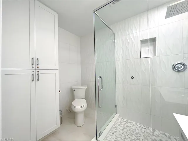a bathroom with a double vanity sink mirror and toilet