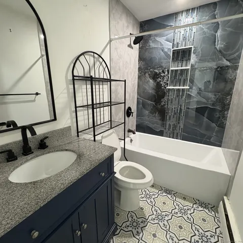 a bathroom with a granite countertop sink toilet and shower