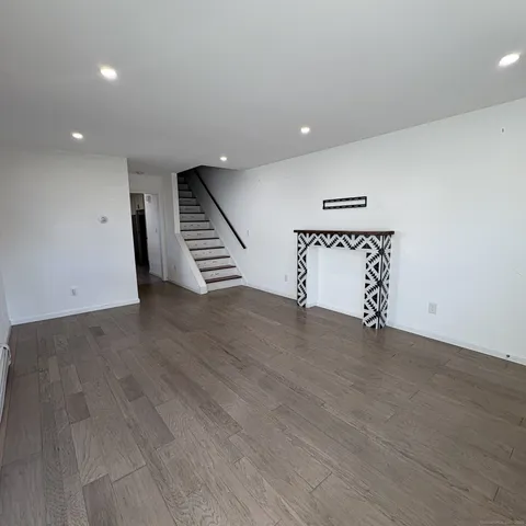 an empty room with wooden floor and stairs