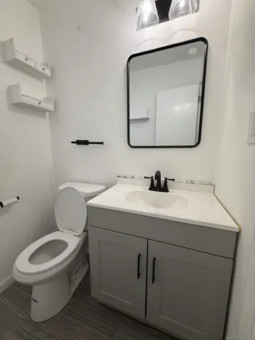 a bathroom with a toilet sink and mirror