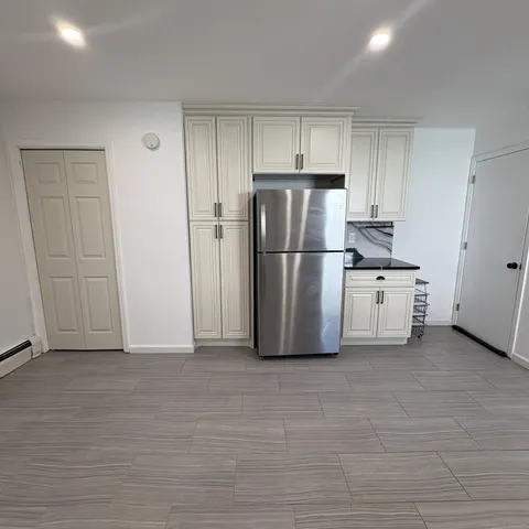 a kitchen with a refrigerator a stove top oven and cabinets