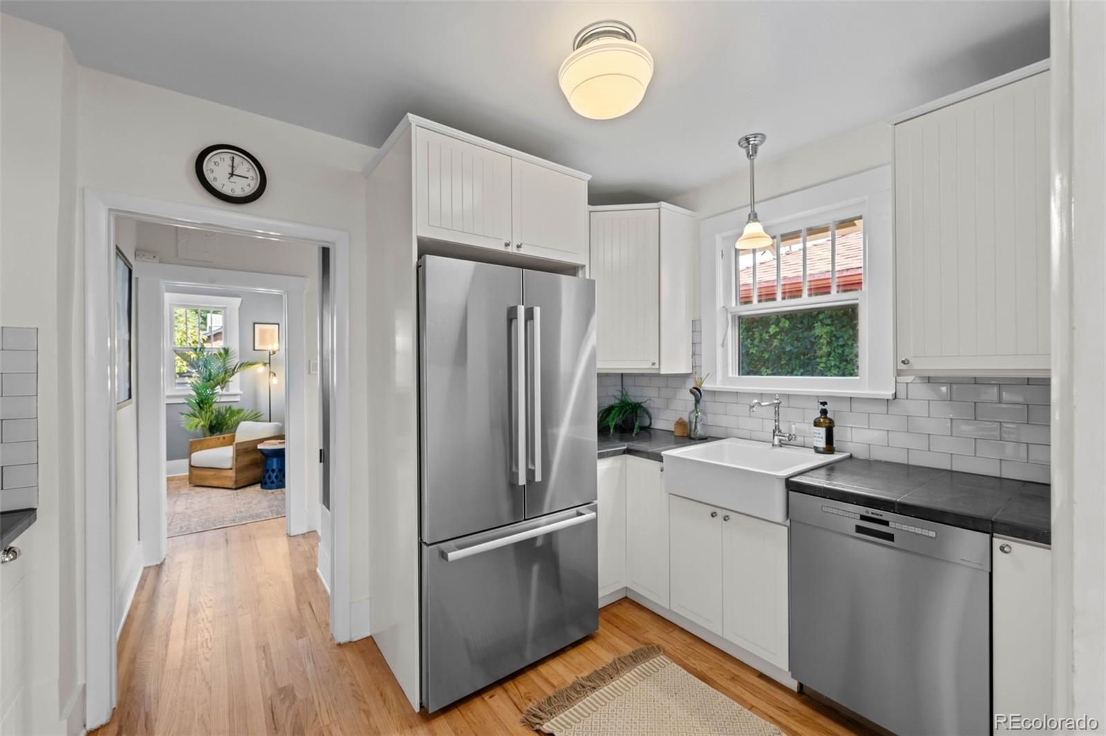 2314 Grape Street Denver, CO 80207 - Photo 17 of 49 a kitchen with a sink cabinets stainless steel appliances and a window