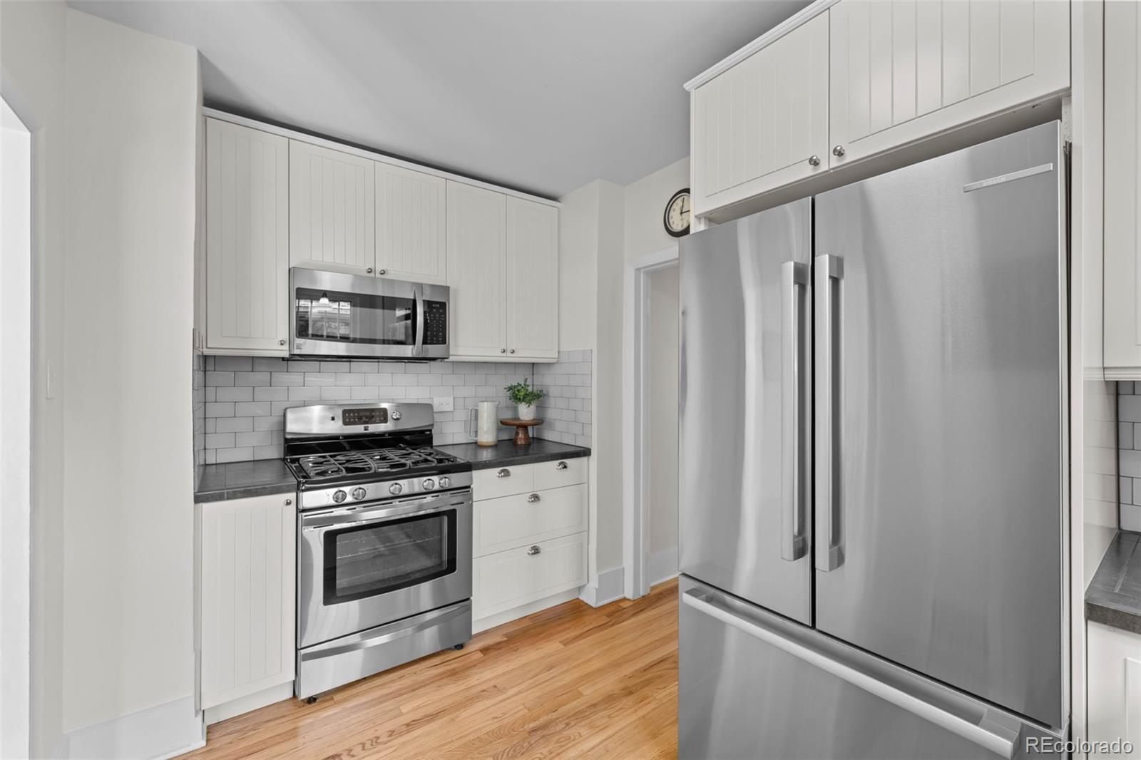 2314 Grape Street Denver, CO 80207 - Photo 18 of 49 a kitchen with stainless steel appliances a stove a refrigerator and a sink