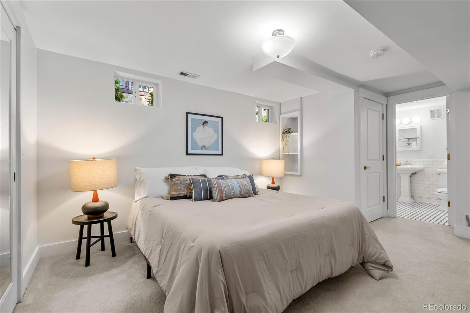 2314 Grape Street Denver, CO 80207 - Photo 30 of 49 a bedroom with a bed and a lamp on table