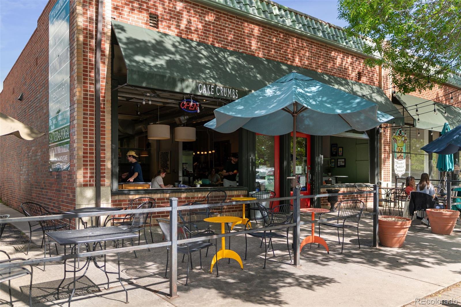 2314 Grape Street Denver, CO 80207 - Photo 43 of 49 a view of the patio with dining table and chairs under an umbrella with a fire pit