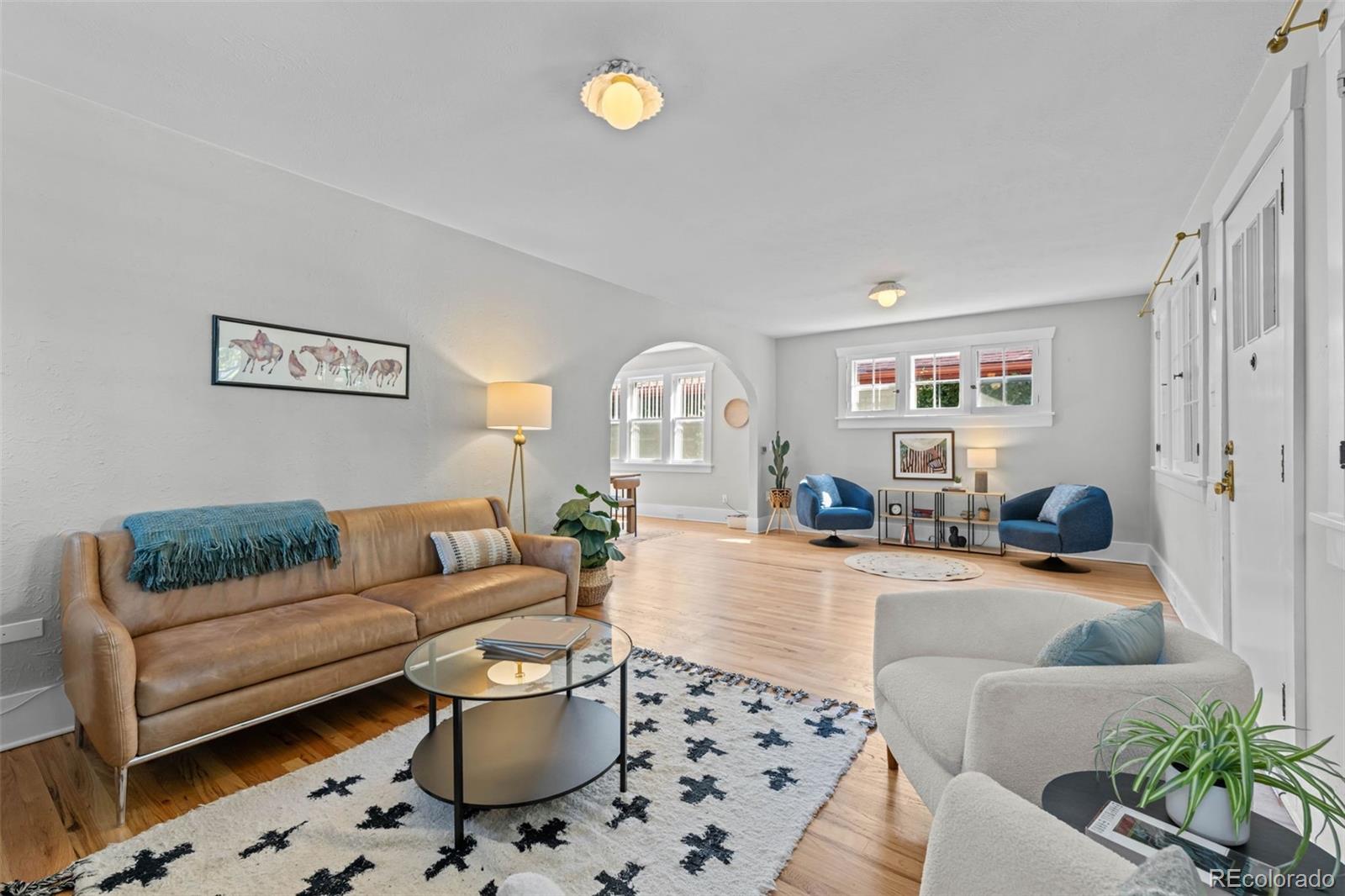 2314 Grape Street Denver, CO 80207 - Photo 10 of 49 a living room with furniture a rug and a chandelier