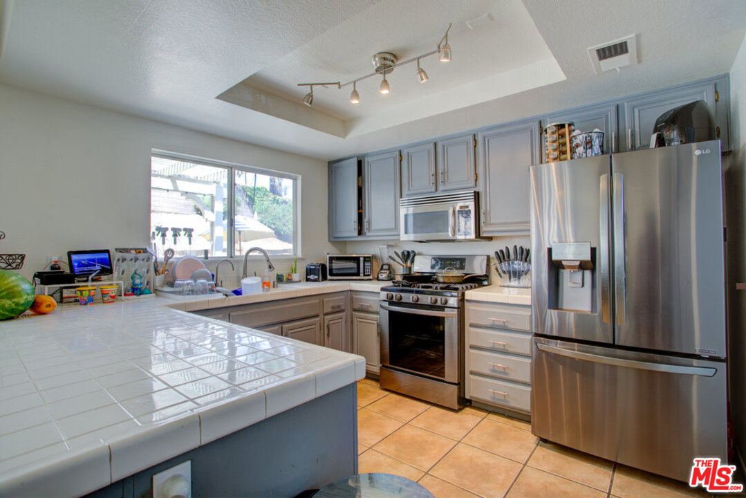 19281 Foxtail Lane Riverside, CA 92508 - Photo 15 of 53 a kitchen with stainless steel appliances granite countertop a refrigerator stove microwave and sink