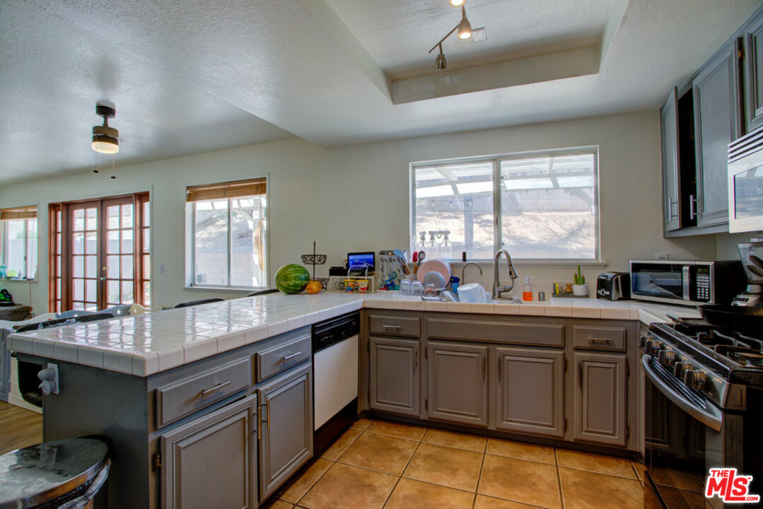 19281 Foxtail Lane Riverside, CA 92508 - Photo 16 of 53 a kitchen with granite countertop a sink stove and cabinets